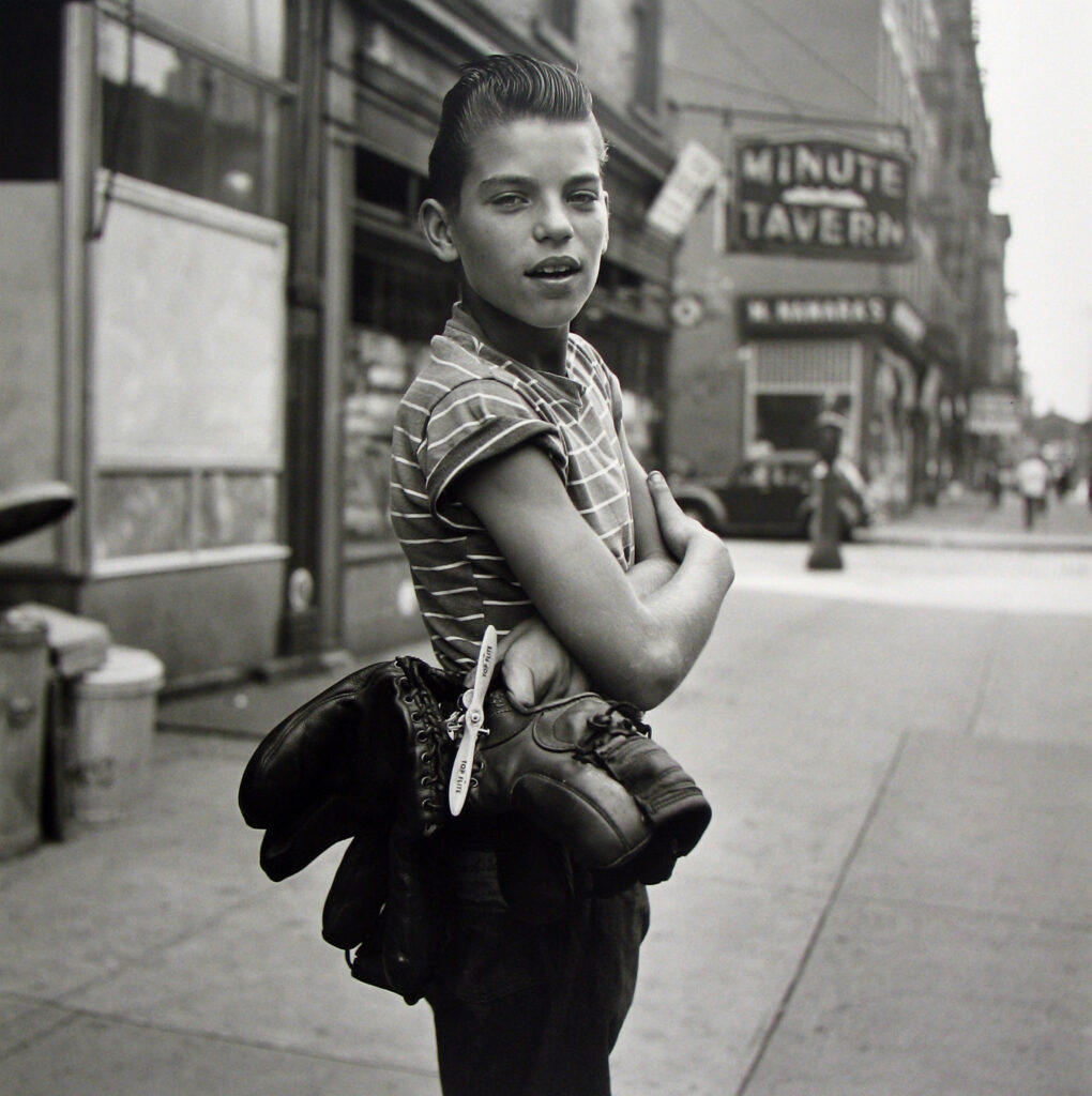 Black and white photo of a young boy holding a model aeroplane.