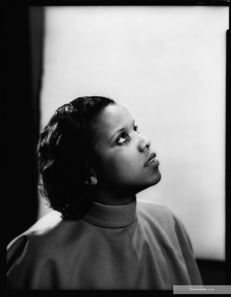 Black and white photograph of young actress looking upwards in a reverential pose.