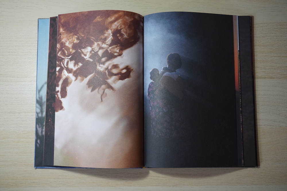 Double page spread. Left: a colour photograph of a ripple in water. Right: A coloured photograph of a person carrying a child on their back. It is difficult to see the figures completely because of the deep blue shadows.