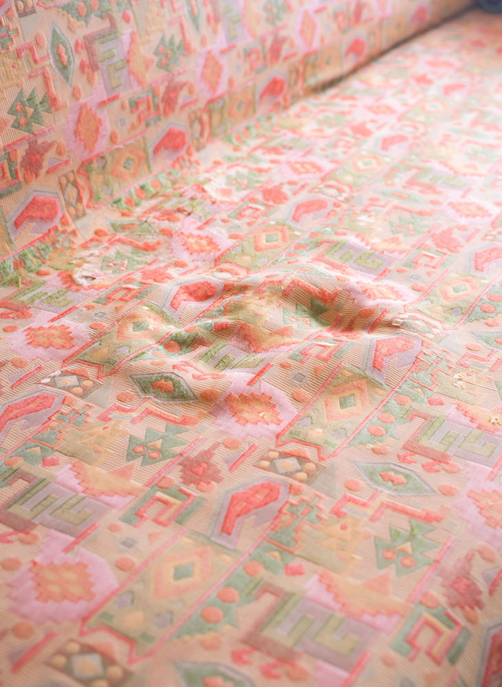 Colour photograph. A slight impression has been left in a pink and green patterned fabric.